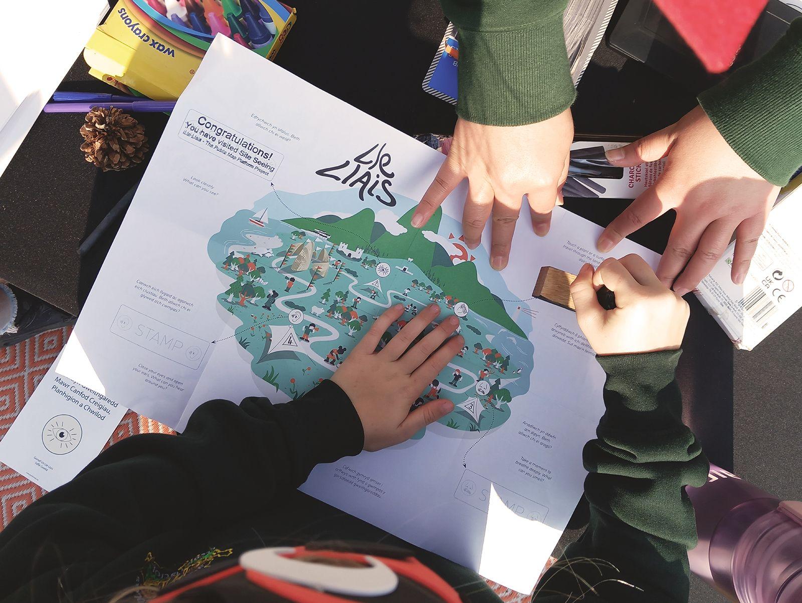 A group of children's hands are doing an activity with a map